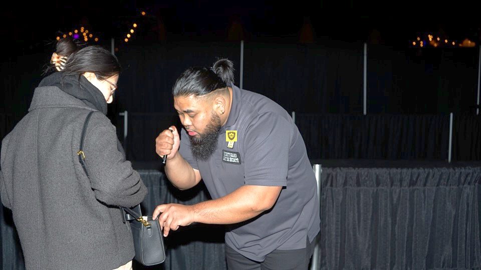 SafeHaven officer performing a bag check at an event entrance